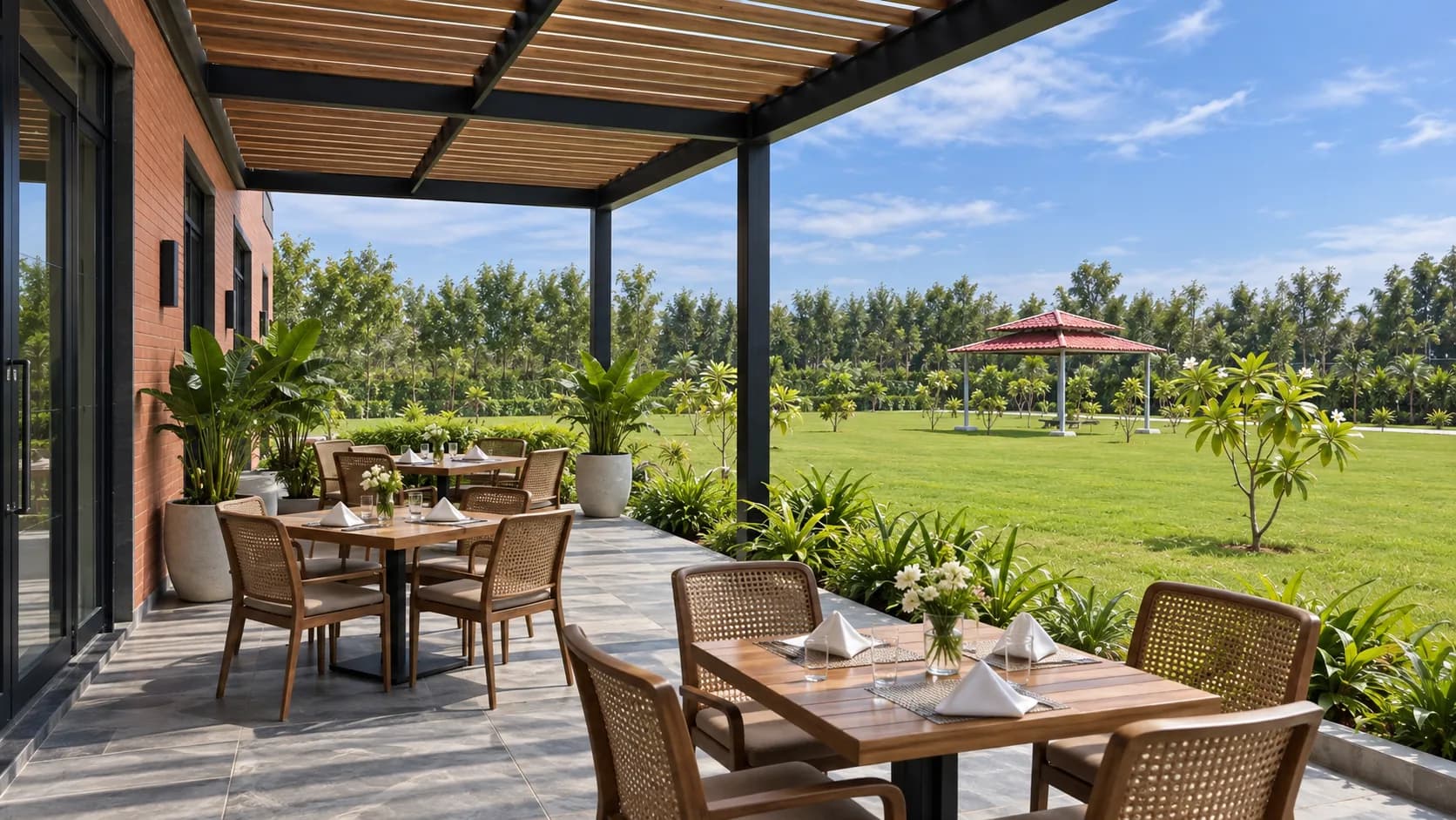 The restaurant's covered terrace: tables laid with white napkins, looking over the lawn to a red-roofed gazebo