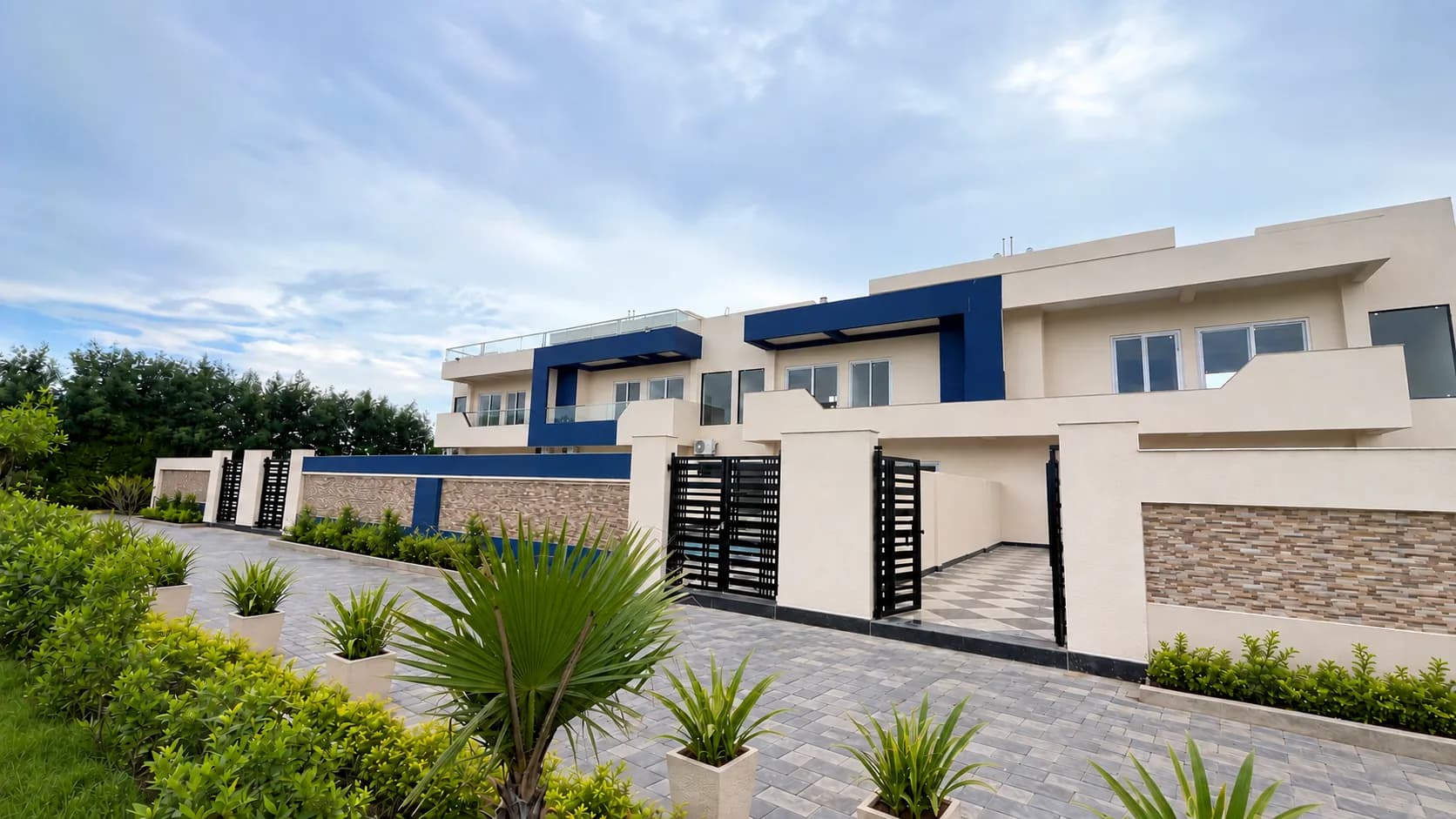 The row of two-storey villas with their navy-blue frames, black gates and potted palms