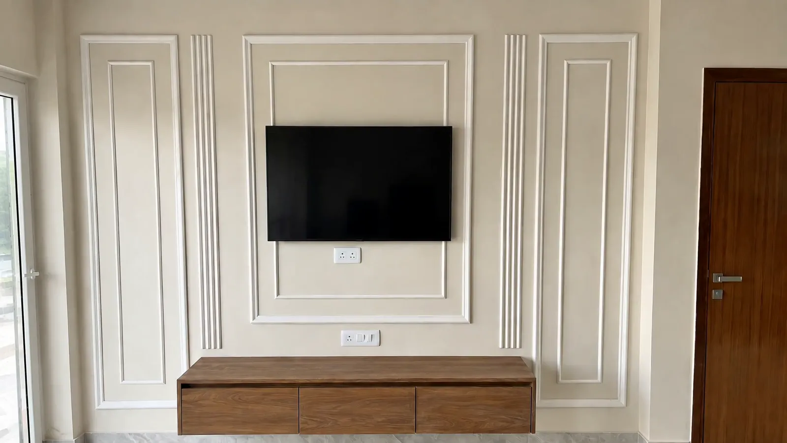 A villa's living room: a panelled cream wall with a television above a low wooden console